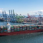 Крупный контейнеровоз на рейде в международном морском порту