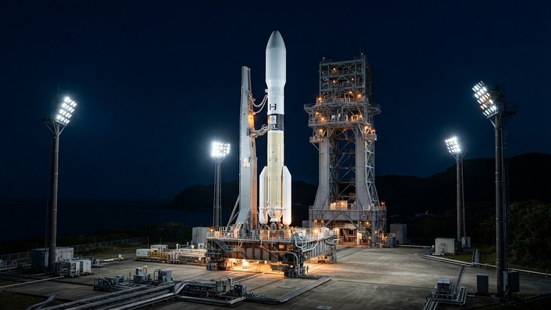 Космическая ракета H3 на стартовой площадке в свете ночных прожекторов