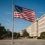 Флаг США перед правительственным зданием на фоне ясного неба