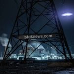Высоковольтная опора на фоне ночного неба с ярким светящимся диском