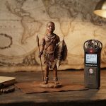 Глиняная фигурка африканского воина стоит на полке рядом с книгой
