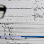 Спасатели за осмотром поврежденной стены здания после подземных толчков