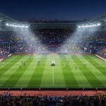 Современный футбольный стадион в Париже с зеленым полем и мячом в центре перед ведомственным матчем