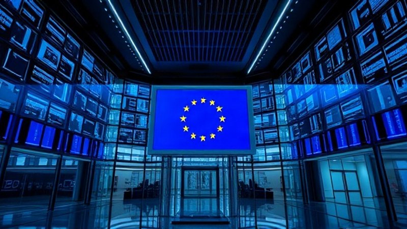 Интерьер высокотехнологичного здания Европейской комиссии в Брюсселе с цифровыми мониторами наблюдения и флагом Европейского Союза в вестибюле