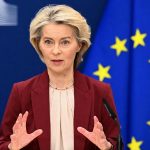 Зал заседаний Совета Европейского Союза с микрофонами и законодательными документами на столах делегаций