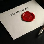 Официальный бумажный вексель с красной сургучной печатью и перьевой ручкой на столе.