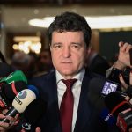 Президентский дворец Котрочень в Бухаресте под ярким дневным светом с элегантным архитектурным фасадом и развевающимся румынским флагом