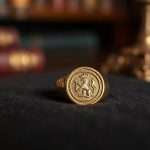 Старинный золотой печатный перстень лежит на черной бархатной салфетке