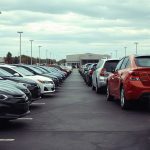Стоянка автомобилей с пробегом в США с аккуратно припаркованными машинами на открытой площадке автосалона.