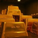 Очищенные золотые слитки, надежно уложенные внутри современного хранилища государственного казначейства в Африке с теплым освещением