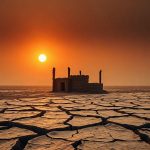Обнажившиеся остатки деревянных и каменных строений затопленного села на высохшей земле водоема в Азии.