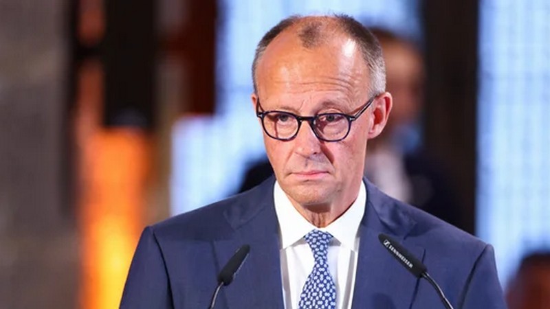 Здание Ведомства федерального канцлера в Берлине в вечерних сумерках с силуэтом государственного деятеля у панорамного окна