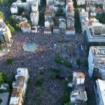 Протестующие на улицах Белграда держат транспаранты во время шествия против правящей партии
