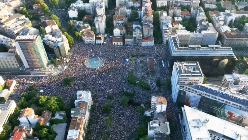 Протестующие на улицах Белграда держат транспаранты во время шествия против правящей партии