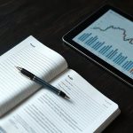 Финансовые документы, планшет и блокнот с ручкой на деревянном столе