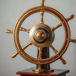 Тяжелый бронзовый навигационный штурвал на полированной подставке.
