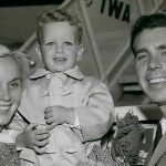 Винтажная театральная гримерка 1950-х годов с освещенным зеркалом, сценарием и белыми розами