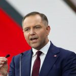 Сельскохозяйственная техника на фоне поля и силуэтов нефтеперерабатывающего завода на закате