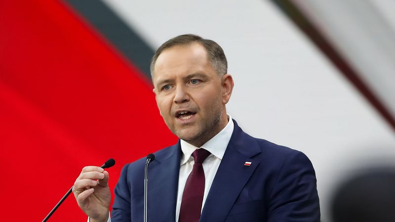 Сельскохозяйственная техника на фоне поля и силуэтов нефтеперерабатывающего завода на закате